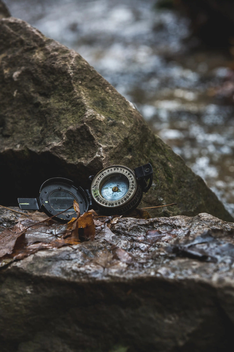 compass placed on wet rock near sea